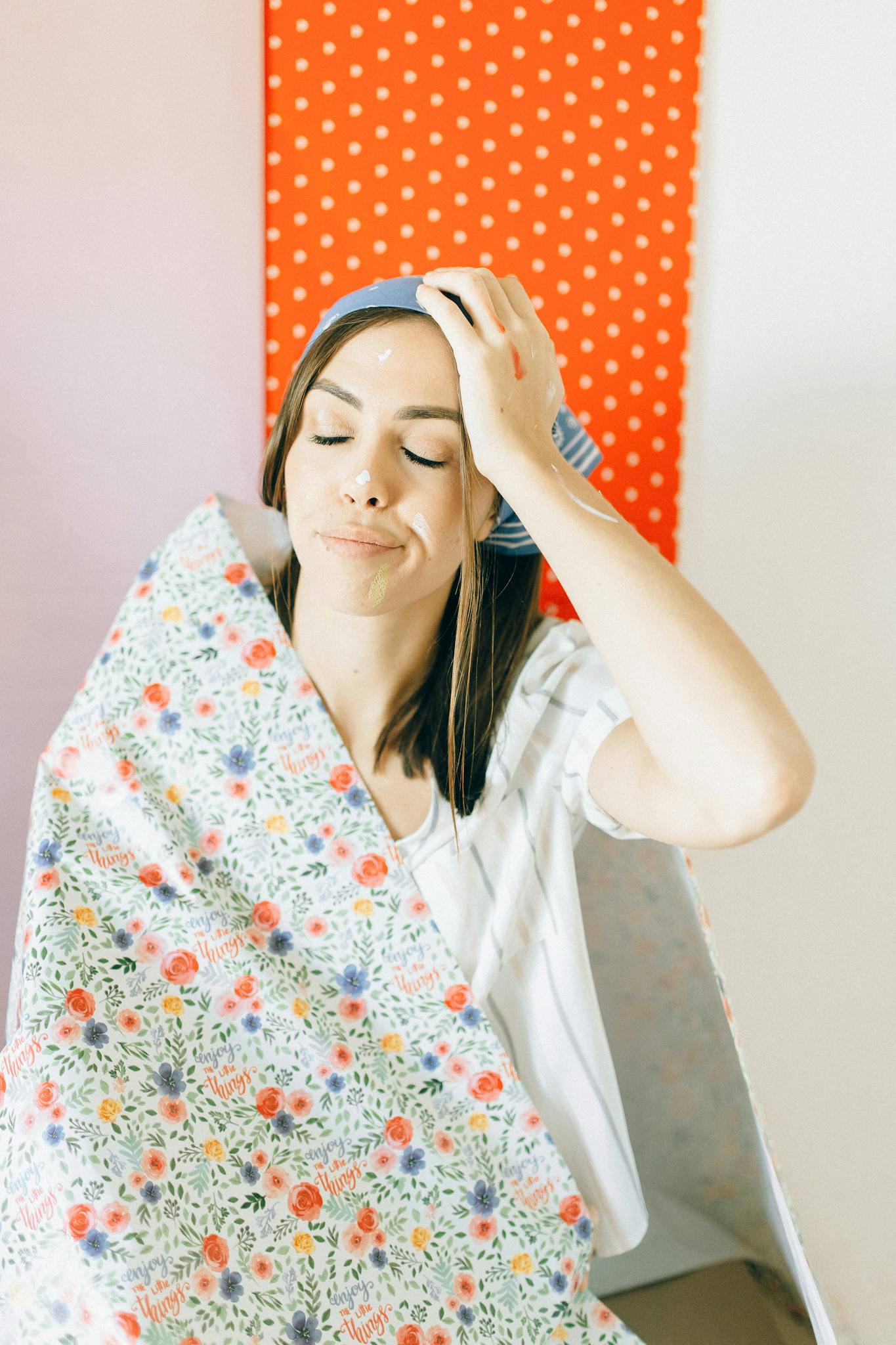 woman in white shirt covering her face